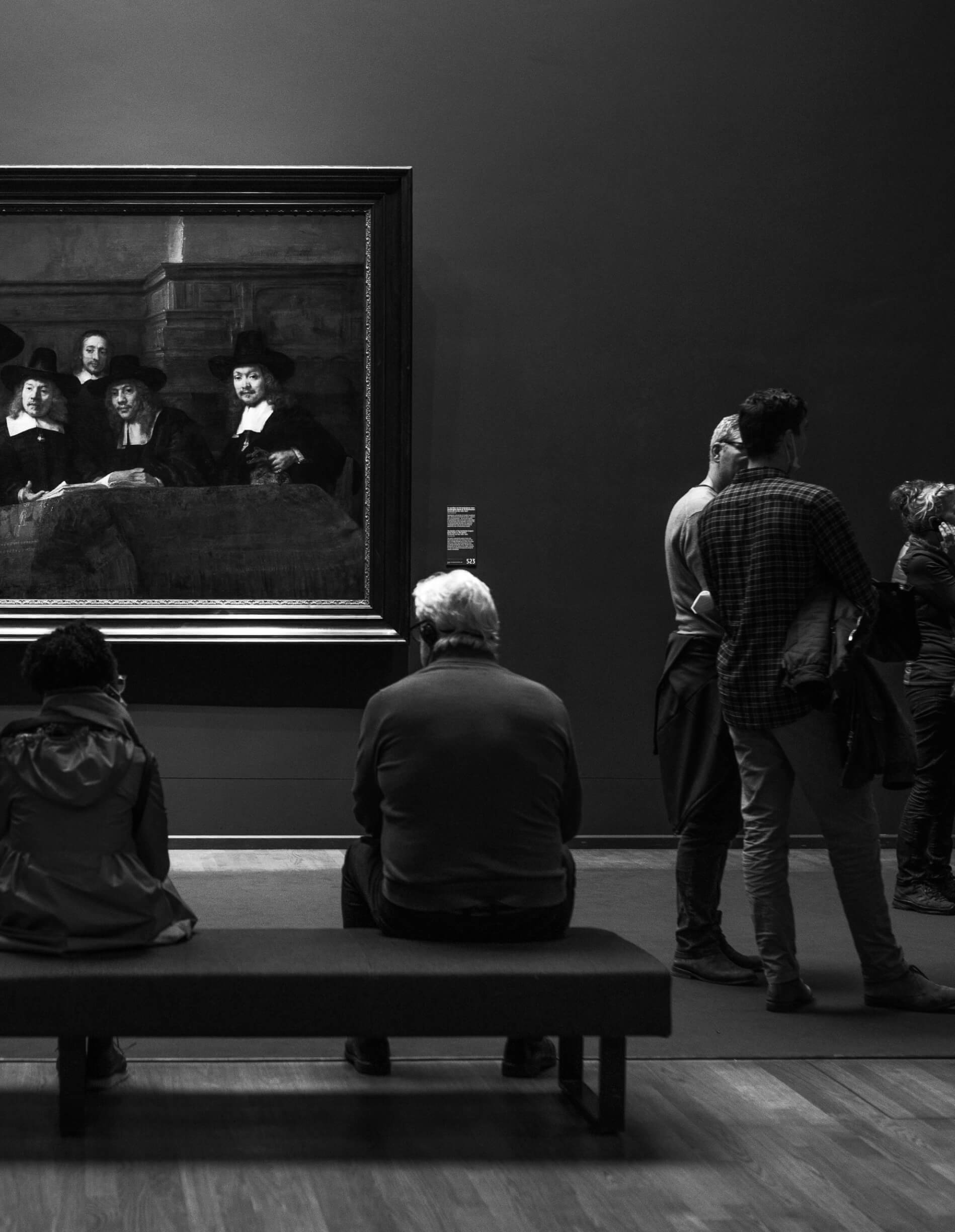 Who We Serve Arts And Culture We serve the Art and Culture Community. An older man is looking at a painting inside a museum.