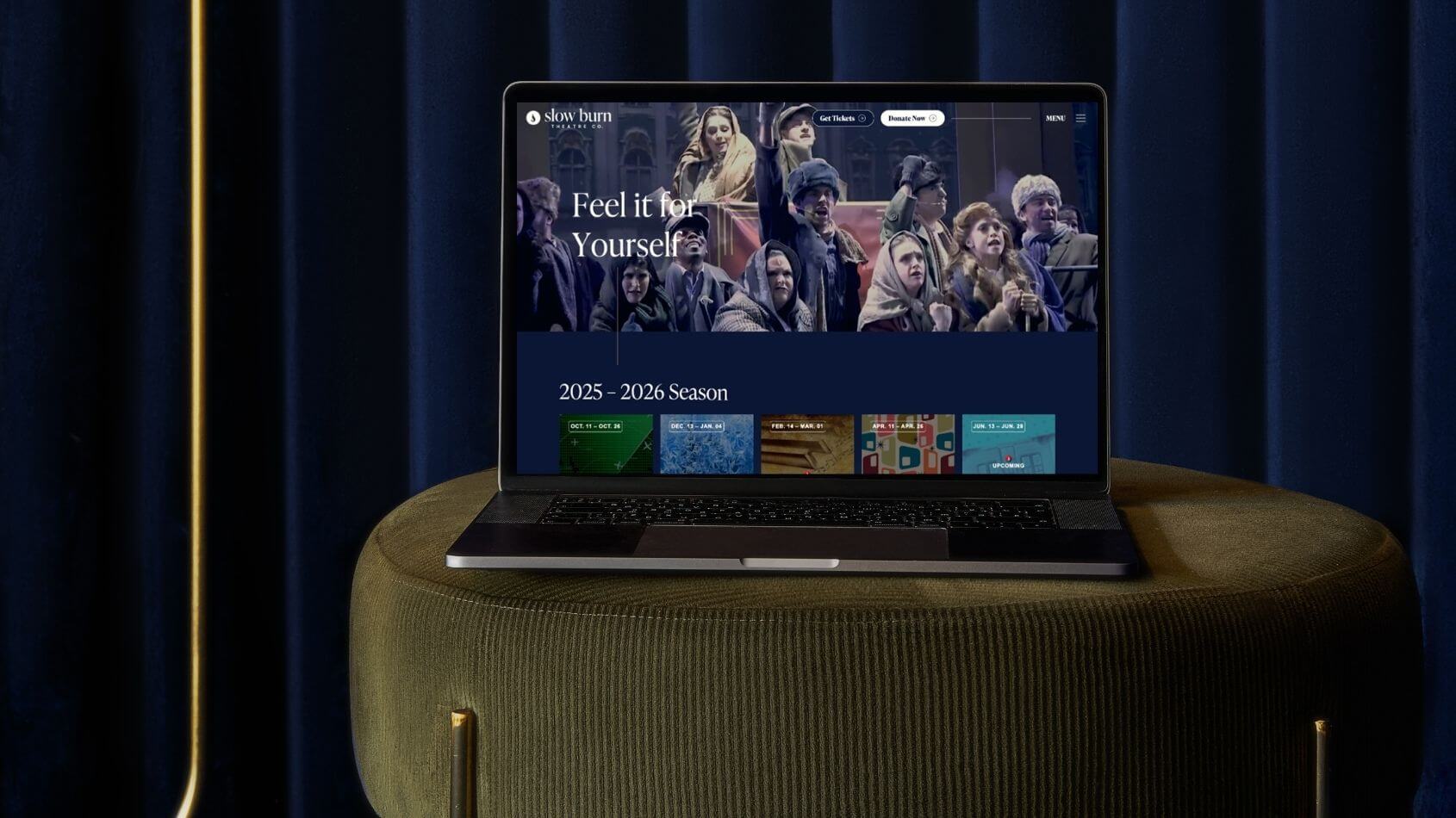 Slow Burn Theatre Co. Website on a laptop, view set up on a stool